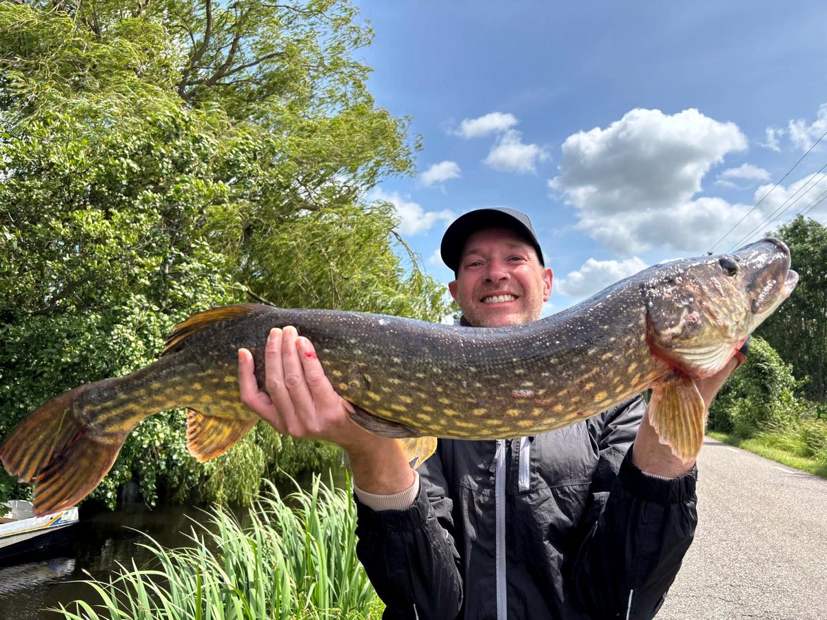 Pescador con un gran lucio en Krimpenerwaard cerca de Slapen in de Polder