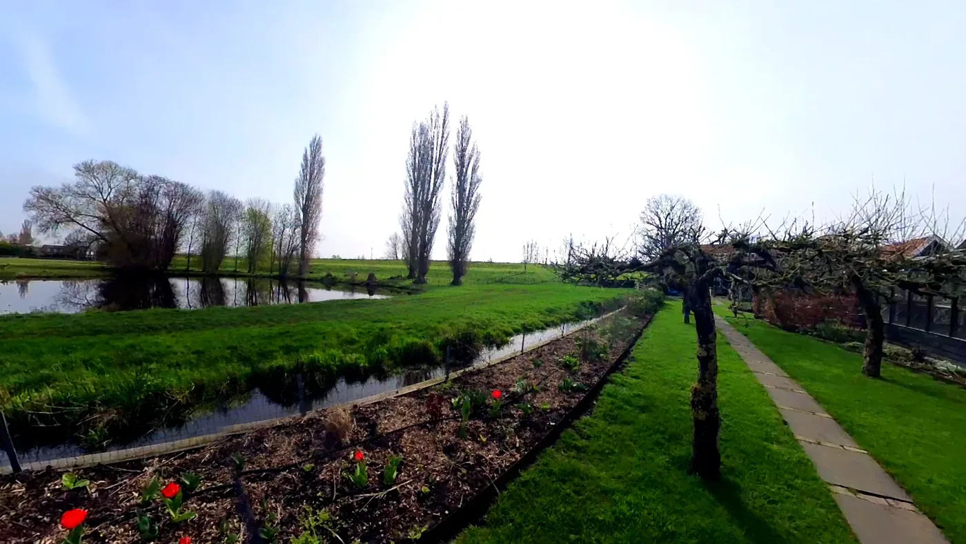 Quiet garden, water ditch and पोल्डर path beside the हॉलिडे कॉटेज.