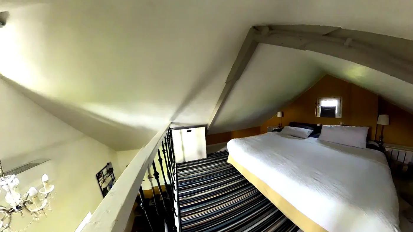 स्लीपिंग लॉफ्ट with double bed above the living room.